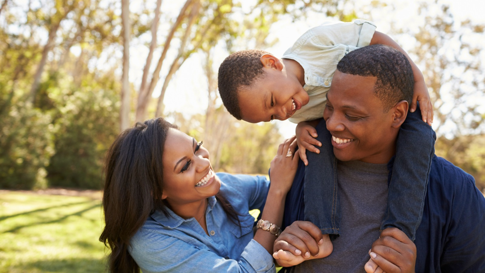 Family smiling at each other outside Happy Family outside
